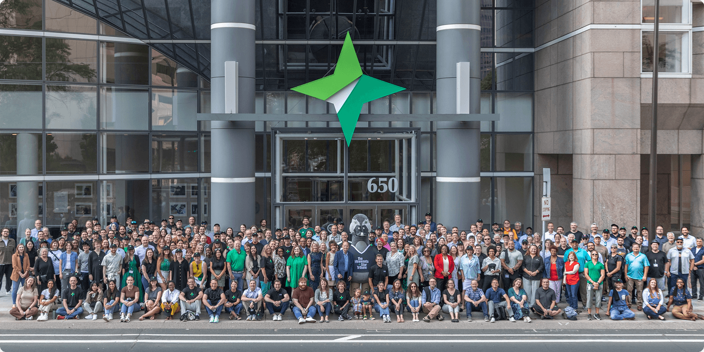 Star Tribune full length photo of employees standing outside the corporate headquarters.