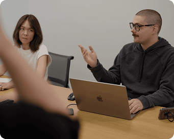 People collaborating with laptops in a meeting room.